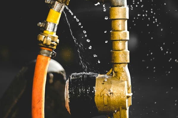 Eau jaillissant d'un raccord de tuyau